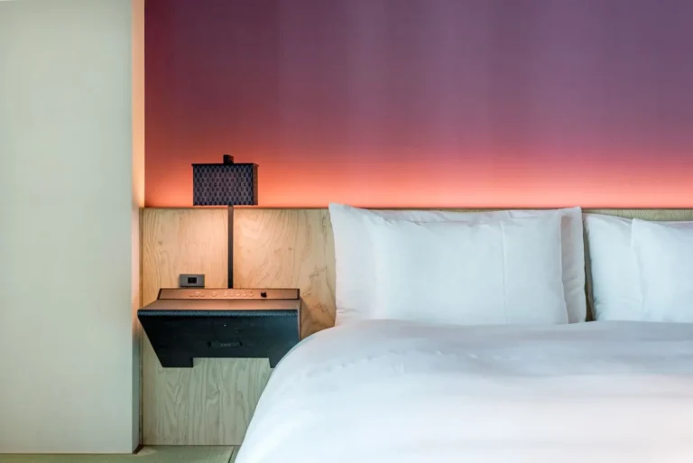 Lit fait avec literie blanche dans une chambre de location courte durée