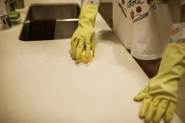Mains gantées nettoyant un comptoir de cuisine en profondeur